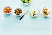 Various salad toppings in bowls and on plate