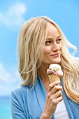 Woman eating ice cream and smiling while looking away