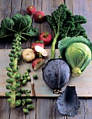 Different types of cabbage and turnips on wooden chopping board