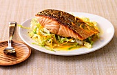 Salmon with cabbage and oranges on plate