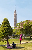 View of people relaxing in park and Cairo Tower in Zamalek, Gezira Island, Cairo, Egypt