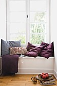 Scatter cushions on window seat in niche