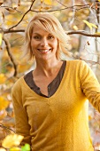Portrait of happy woman wearing yellow sweater, smiling
