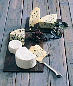 Various cheese and red grapes on small wooden boards