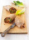 Vegetable wrapped with pancakes on wooden board