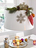 Lampshade decorated with pinecones, branches and spheres for Christmas
