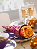 Close-up of rose wrapped in purple paper on plate