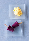 Two serving plates with peach and apricot ice cream and blueberry ice cream stick