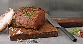 Close-up of roast beef in salt crust on wooden board