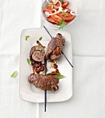 Beef rolls with tomato salad in serving dish, overhead view