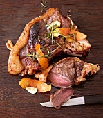 Steak with rosemary, lemon and orange on wooden board