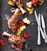 Close-up of roasted lamb shanks with vegetables on pan