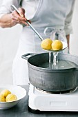 Kartoffelklösse werden aus Kochwasser gehoben