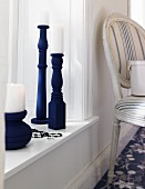 Blue candlesticks made from table legs on windowsill
