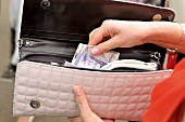 Close-up of woman removing money from purse, Berkshire, London, UK