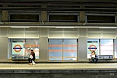 People Sitting on Underground station platform, Shoreditch High Street, London, UK