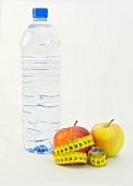 Water bottle and measuring tape around apples on white background, Icon image for diet