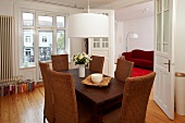 Dining area with wicker chair, wooden table and hanging light