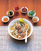 Thai soup with rice noodles and meatballs in bowl