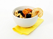 Bowl of various dried fruits on white background