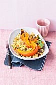Baked pumpkin wedges on a bed of couscous