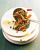 Penne rigate pasta with peas and prosciutto on plate