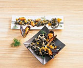 Black and white tagliatelle with mussels on plates