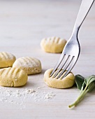 Close-up of gnocchi dough being pricked with fork