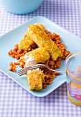 Fish fingers with red risotto on plate