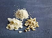 Pine nuts, almonds and sesame on gray surface