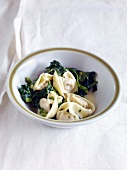 Tortellini with spinach in bowl