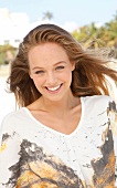 Portrait of happy blonde woman wearing patterned white shirt, smiling