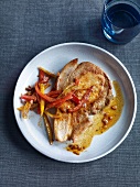 Pork cutlet with peppers on plate, overhead view