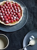 Lemon tart topped with raspberries on plate