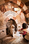 Tourist filling water in can at Muzesi Veli Dervish Monastery Lion, Cappadocia, Turkey