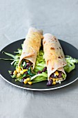 Enchiladas with spinach, sweetcorn and black beans on iceberg lettuce