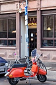 Red Vespa parked on Nauwieser Street, Saarland, Germany