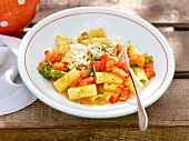 Rigatoni with fresh tomato sauce and spoon in serving dish