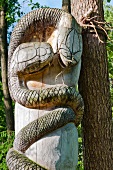 Close-up of wooden sculpture besides tree, Galindia Mazurski Eden, Warmia Masuria, Poland