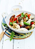 Basil gnocchi with Sicilian summer vegetables in bowl