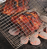 Spareribs between two grids on barbecue