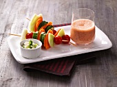 Raw food skewers, cream cheese dip and glass of vegetable smoothie on tray