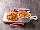 Heart shaped waffles with bowl of mango and papaya compote on tray