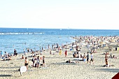 View of people and sea at Platja de la Barceloneta beach in Barcelona, Spain