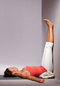 Beckenboden-Yoga, Frau in Rückenlage, Beine an der Wand