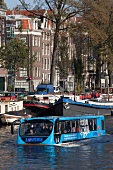 People travelling in floating bus in Oudeschans, Amsterdam, Netherlands