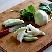 Close-u of peeled kohlrabi cut into pieces on wooden board, step 2