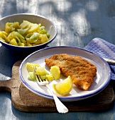 Schnitzel with potato and cucumber salad on plate