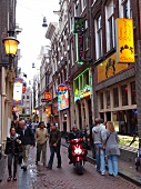 View of tourists in alley with different bars in Binnenstad, Amsterdam, Netherlands