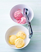Plum and peach ice-cream in bowls with ice-cream scoop